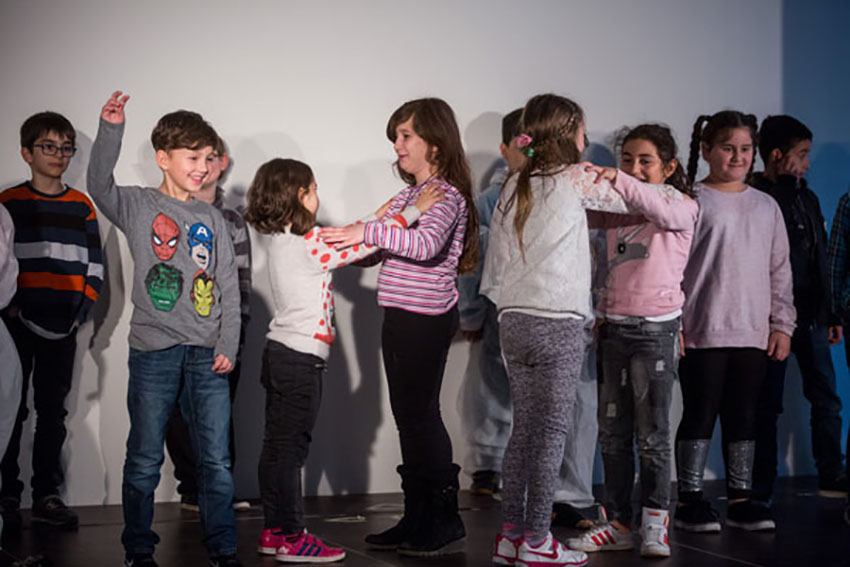 Kinder tanzen zusammen auf der Bühne.