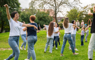 Menschen tanzen zusammen im Park.