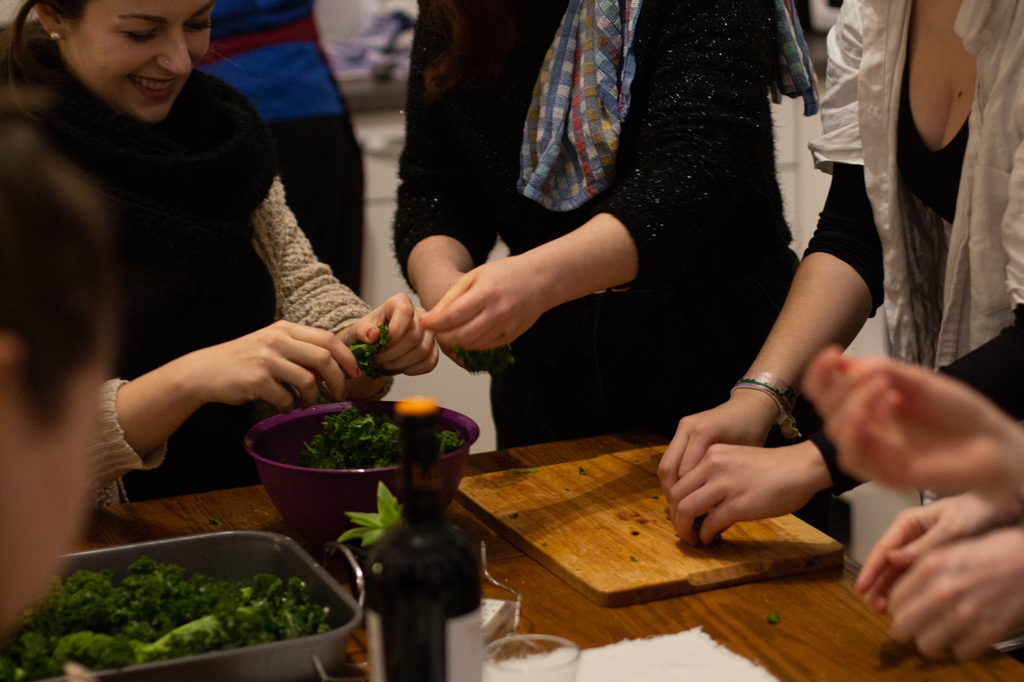 Menschen bereiten gemeinsam einen Salat zu.